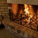 Old,Brick,Fireplace,With,A,Forged,Grate,And,Burning,Wood